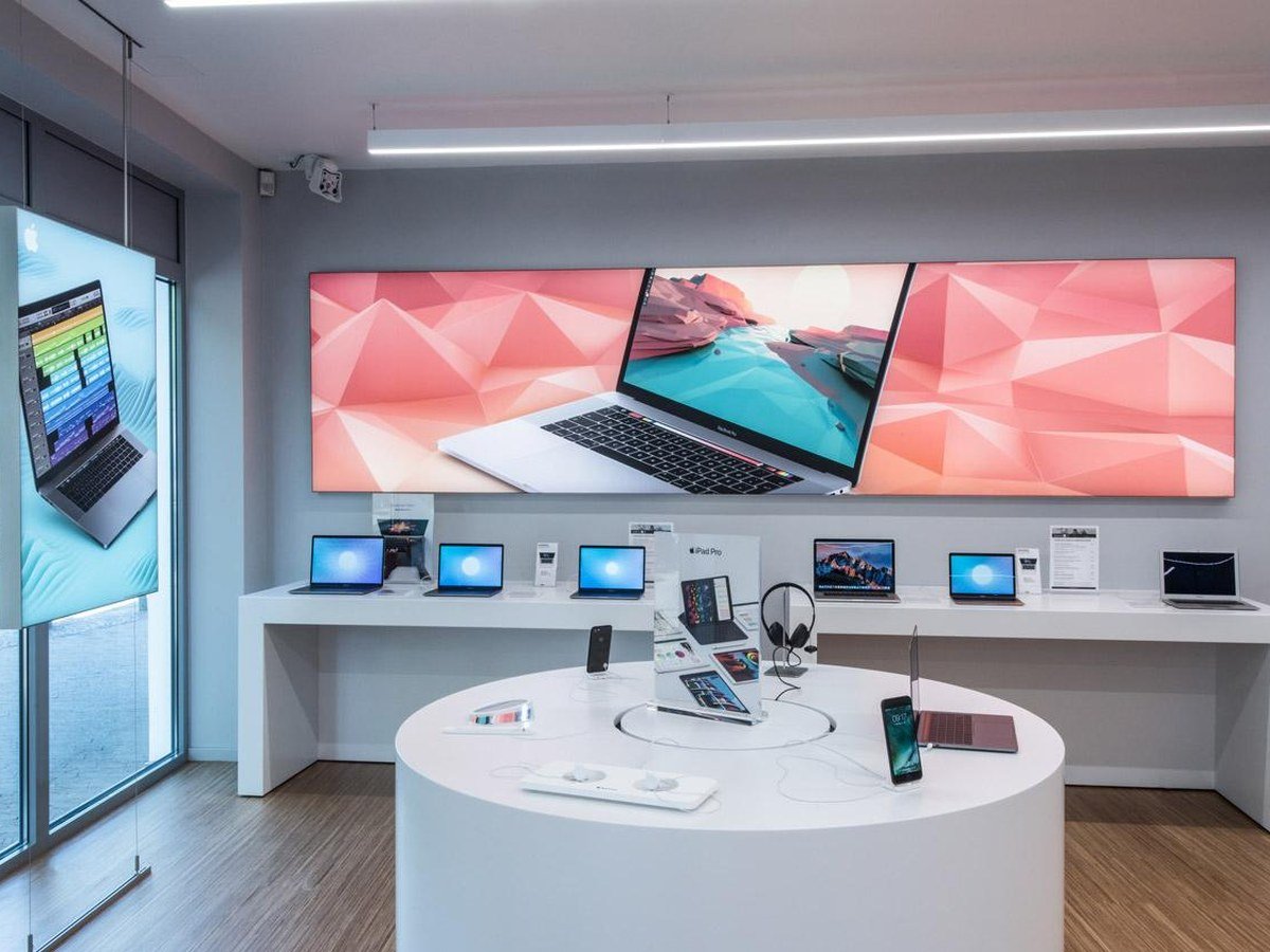 Backlit graphic wall display with laptops and accessories on shelving