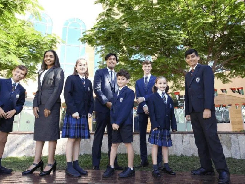 School students in blazer and skirt or trouser uniforms outdoors