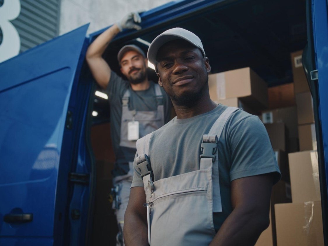 Delivery and logistics team in branded uniforms loading a van